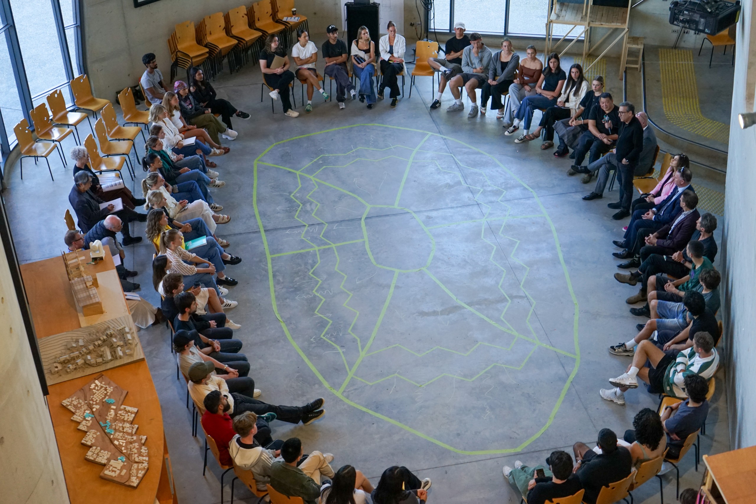 A large group sits in a circle at Bond University