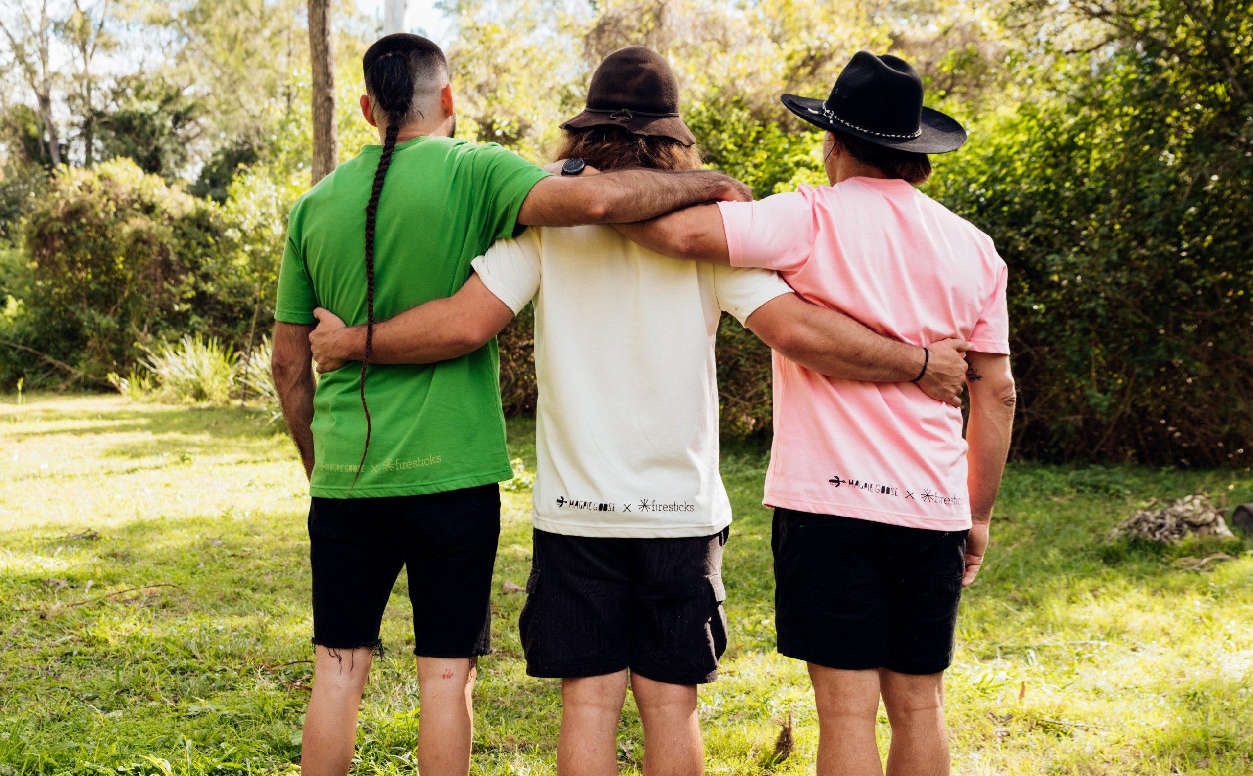 Group stands facing away from the camera in Firesticks x Magpie Goose Tees